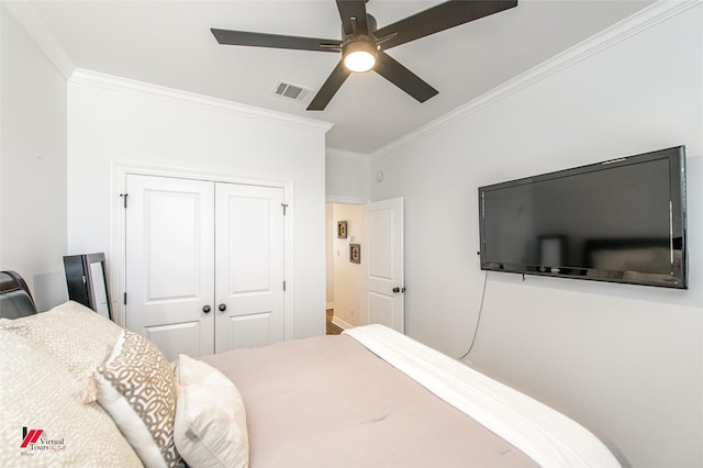 bedroom with ceiling fan, ornamental molding, and a closet