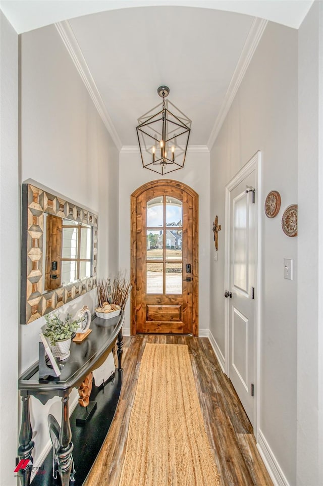 foyer featuring a chandelier, dark hardwood / wood-style floors, and crown molding