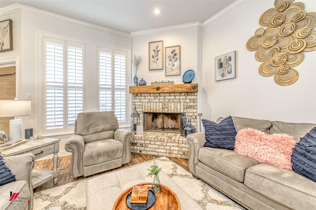 living room featuring hardwood / wood-style flooring, ornamental molding, and a brick fireplace