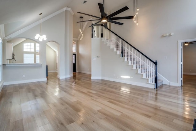 unfurnished living room featuring high vaulted ceiling, ceiling fan, and light wood-type flooring