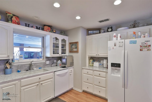 kitchen featuring white appliances, white cabinetry, and sink