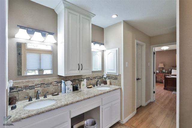 bathroom featuring wood-type flooring, vanity, and backsplash