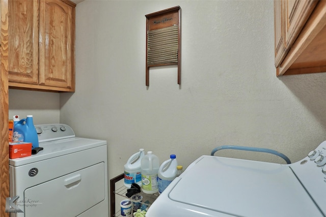 laundry area with washer and clothes dryer and cabinets