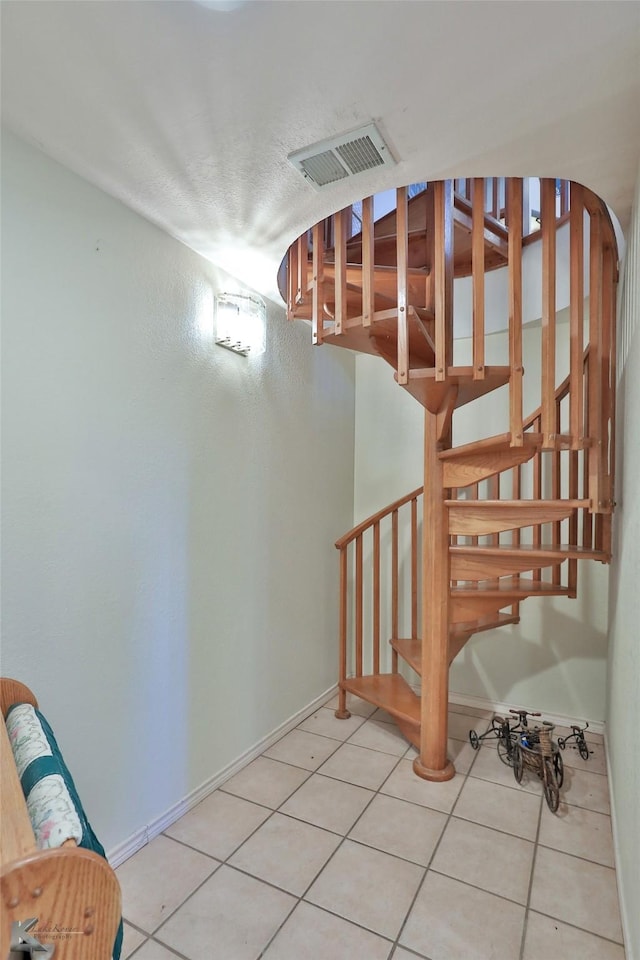 staircase featuring tile patterned flooring