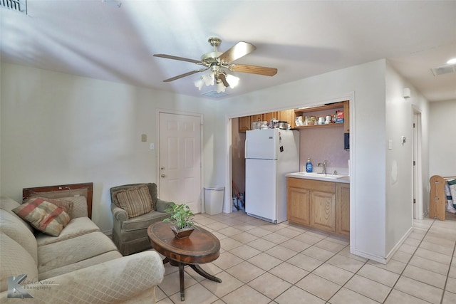 tiled living room with ceiling fan and sink