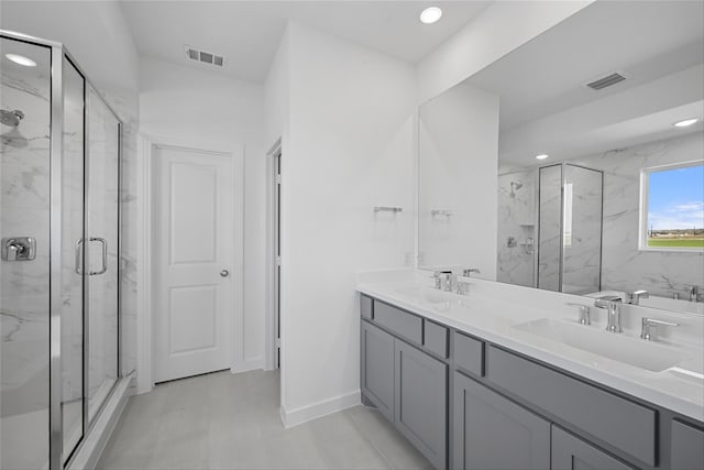 full bathroom with a marble finish shower, a sink, and visible vents