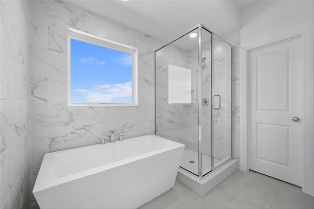 full bath with a marble finish shower and a freestanding bath