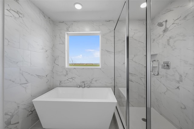 full bath with recessed lighting, tile walls, a soaking tub, and a stall shower
