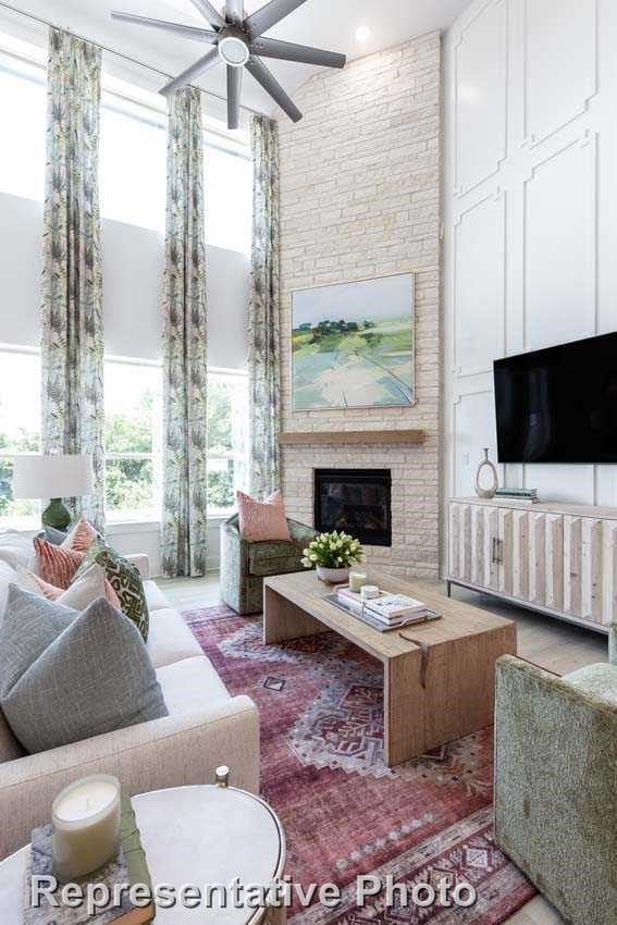 living room with ceiling fan, hardwood / wood-style floors, and a fireplace