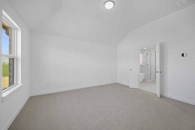 interior space featuring lofted ceiling, baseboards, carpet flooring, and visible vents