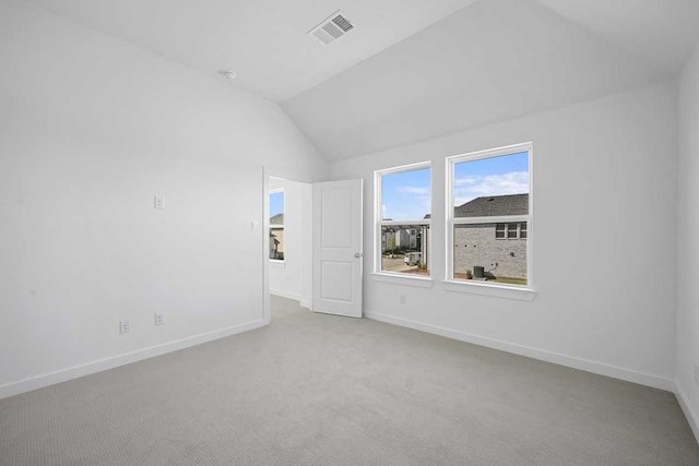 unfurnished room with lofted ceiling, visible vents, baseboards, and carpet