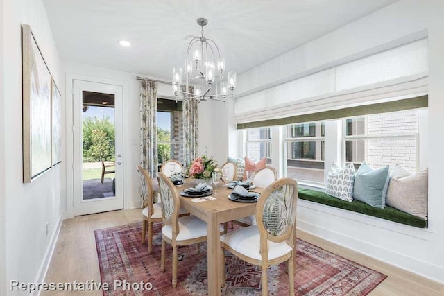 dining room with light hardwood / wood-style flooring, an inviting chandelier, and plenty of natural light