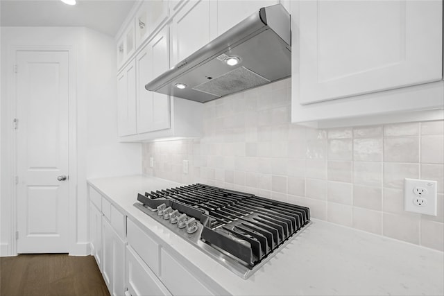 kitchen with stainless steel gas stovetop, white cabinetry, decorative backsplash, and exhaust hood