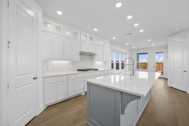 kitchen featuring a kitchen island with sink, appliances with stainless steel finishes, decorative backsplash, sink, and decorative light fixtures