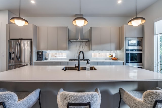 kitchen featuring stainless steel appliances, gray cabinetry, tasteful backsplash, hanging light fixtures, and sink