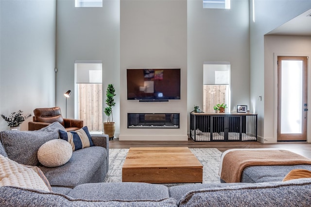 living room with a towering ceiling and hardwood / wood-style flooring