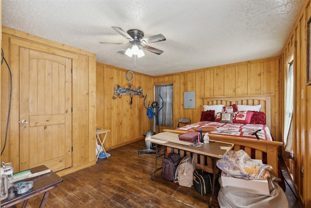 bedroom featuring wood walls, electric panel, ceiling fan, a textured ceiling, and dark hardwood / wood-style flooring