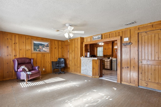 unfurnished room featuring ceiling fan and wood walls