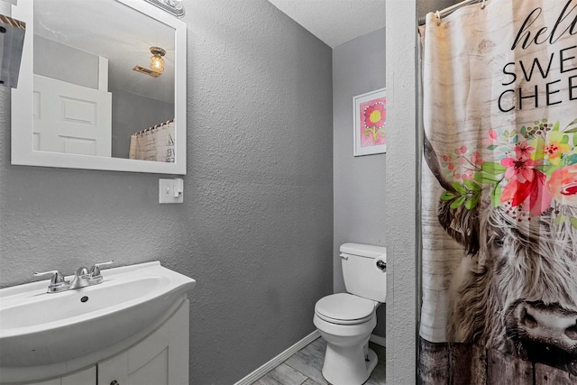 bathroom featuring a shower with curtain, a textured ceiling, toilet, and sink