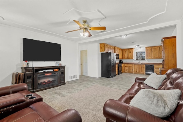 living room featuring light hardwood / wood-style flooring, ceiling fan, and sink