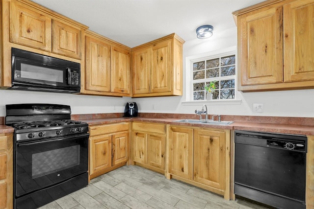 kitchen with sink, light hardwood / wood-style flooring, and black appliances