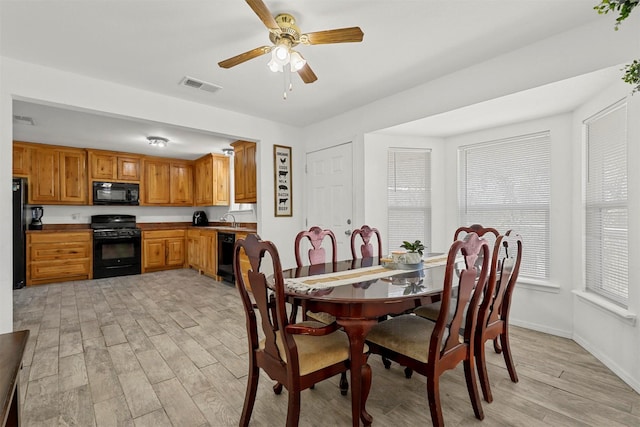 dining area with light wood-type flooring, ceiling fan, and sink