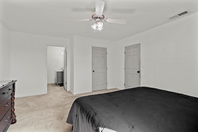 carpeted bedroom featuring ensuite bath and ceiling fan