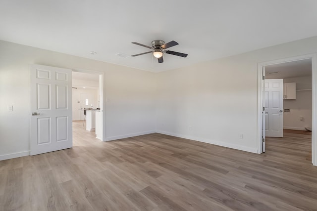 empty room with ceiling fan and light hardwood / wood-style floors