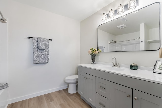 bathroom featuring a shower, wood-type flooring, vanity, and toilet