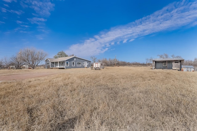 view of yard with a rural view and a storage shed