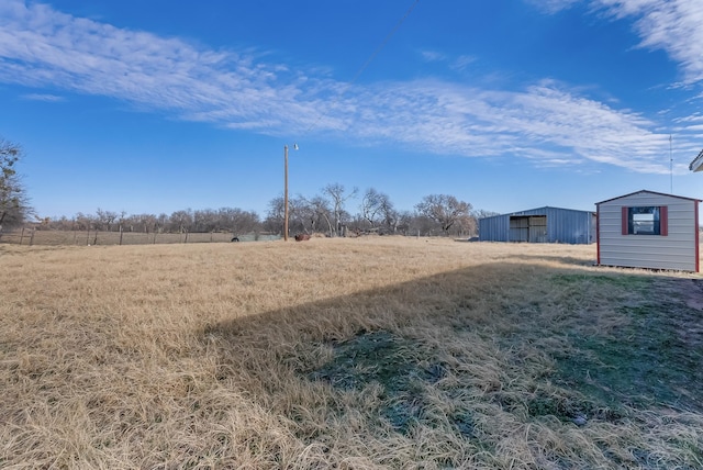 view of yard featuring a rural view and an outdoor structure