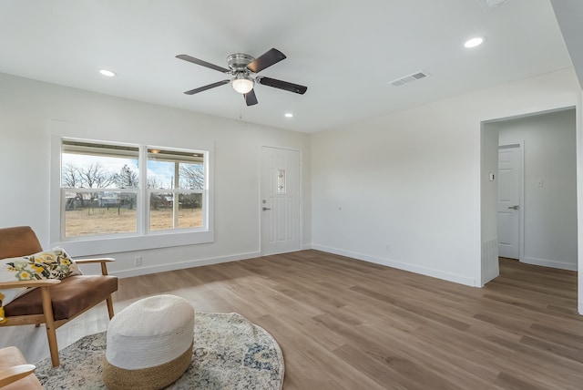 sitting room with ceiling fan and hardwood / wood-style flooring