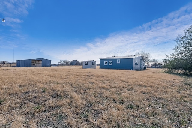 view of yard with a storage unit and a rural view