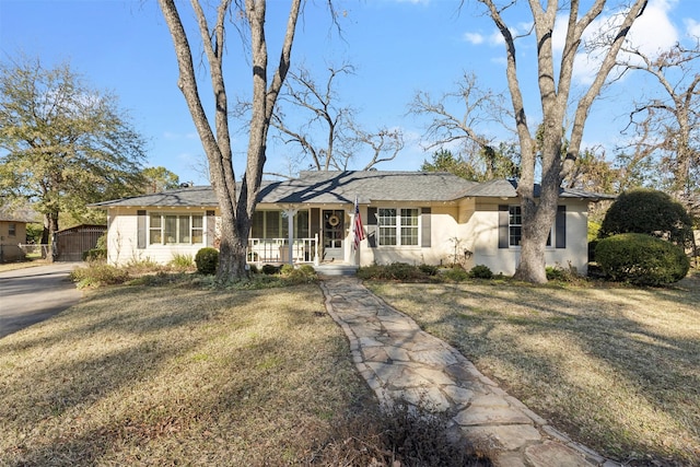 ranch-style house featuring a porch and a front yard