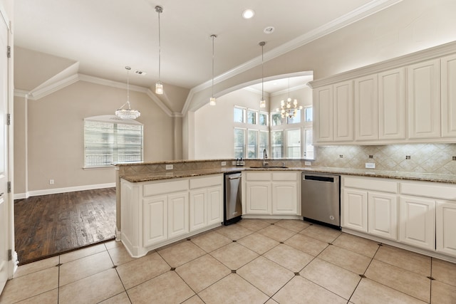 kitchen featuring stainless steel dishwasher, sink, pendant lighting, light tile patterned floors, and an inviting chandelier