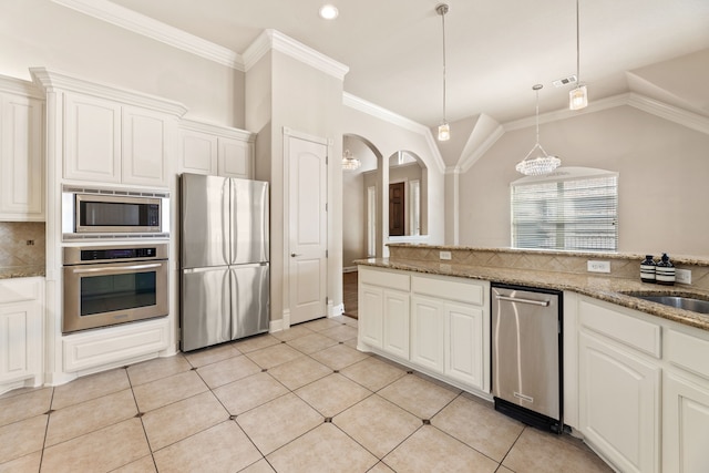 kitchen with white cabinets, light stone counters, lofted ceiling, and stainless steel appliances