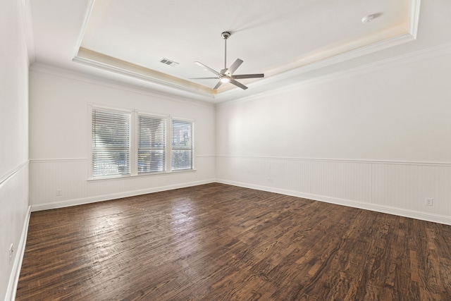 unfurnished room featuring a tray ceiling, dark hardwood / wood-style floors, crown molding, and ceiling fan