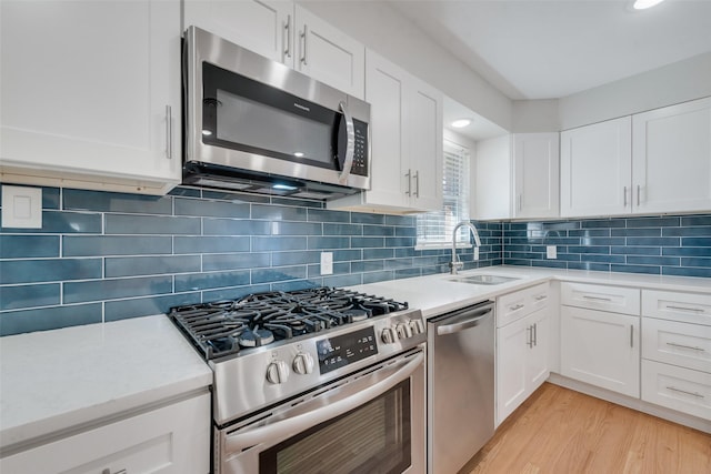 kitchen featuring backsplash, sink, white cabinetry, and stainless steel appliances