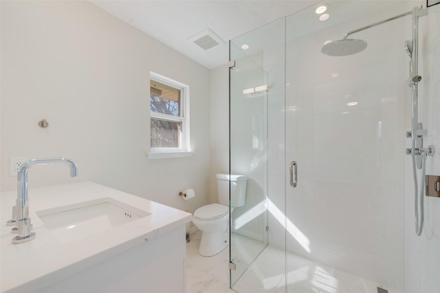 bathroom featuring a shower with door, vanity, and toilet