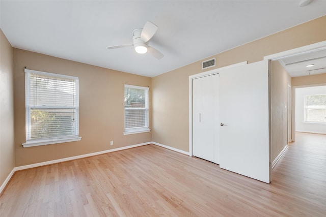 unfurnished bedroom with multiple windows, ceiling fan, and light hardwood / wood-style floors