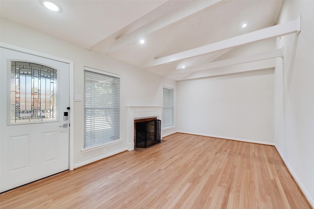 unfurnished living room featuring lofted ceiling with beams and light wood-type flooring