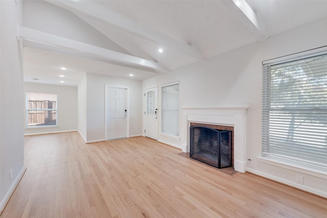 unfurnished living room featuring lofted ceiling with beams and light wood-type flooring