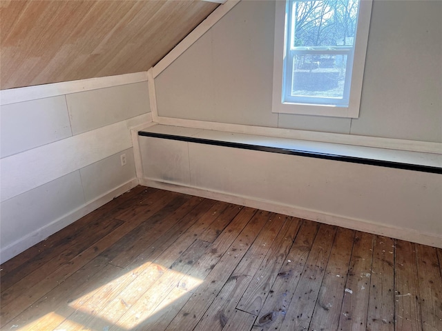 additional living space featuring vaulted ceiling and hardwood / wood-style flooring