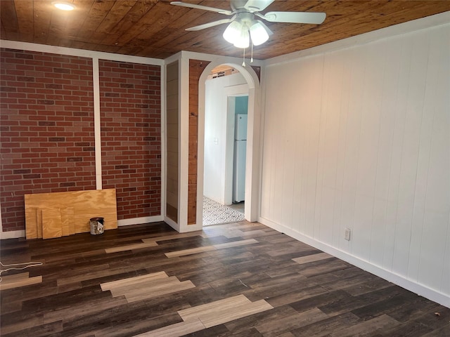 unfurnished room featuring wood ceiling, crown molding, brick wall, ceiling fan, and dark hardwood / wood-style floors