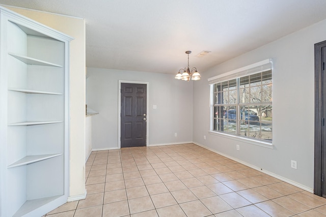 unfurnished dining area with built in shelves, light tile patterned floors, and a chandelier