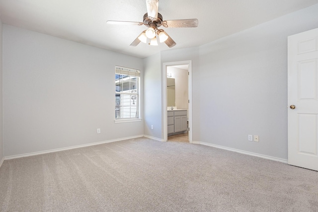 unfurnished bedroom featuring light colored carpet, ceiling fan, and ensuite bathroom