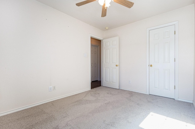 unfurnished bedroom with ceiling fan and light colored carpet