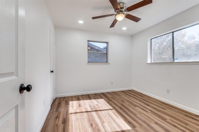 unfurnished room with a wealth of natural light, ceiling fan, and hardwood / wood-style flooring