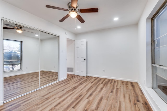 unfurnished bedroom featuring light hardwood / wood-style floors, a closet, and ceiling fan