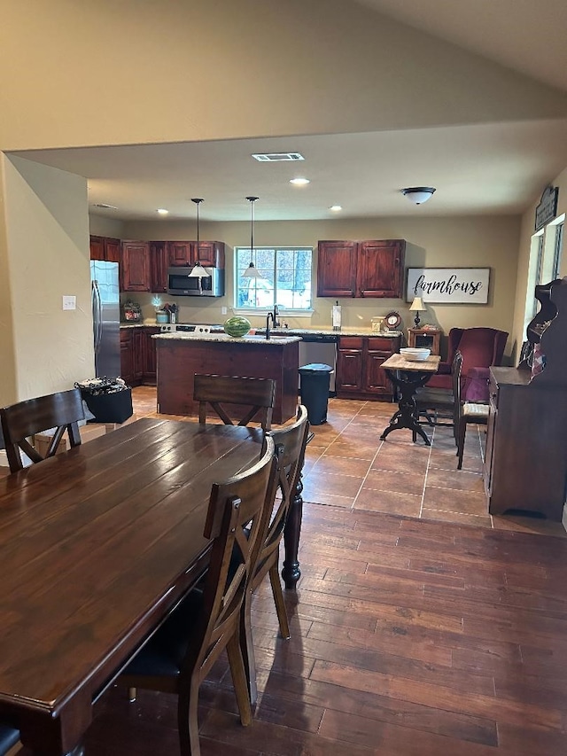 dining space featuring hardwood / wood-style flooring, lofted ceiling, and sink